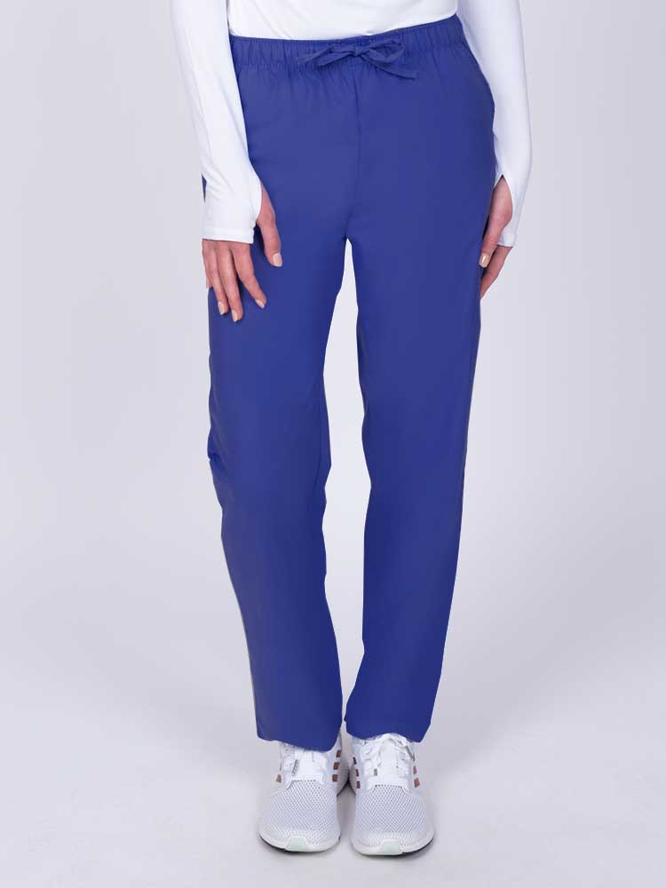 Young woman wearing a Luv Scrubs by MedWorks Women's Elastic Waist Cargo Pant in royal featuring one cargo pocket on the wearer's left side.