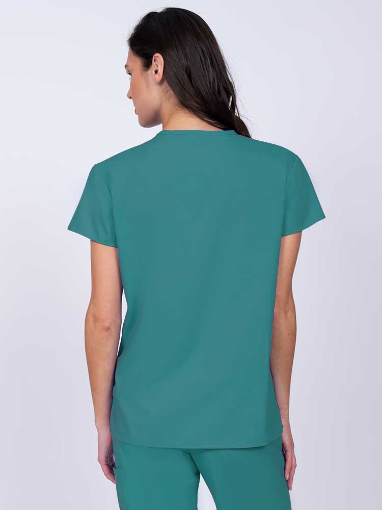 Nurse wearing a Luv Scrubs by MedWorks Women's Mock Wrap Scrub Top in teal with shoulder yokes to ensure a flattering fit.