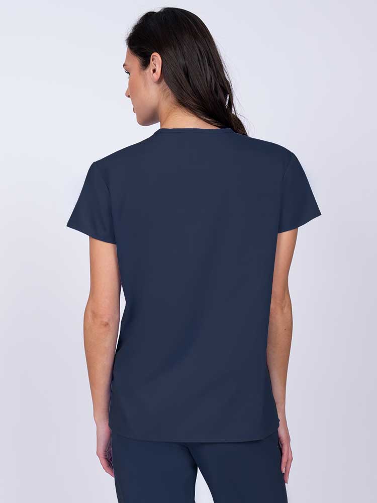 Woman wearing a Luv Scrubs by MedWorks Women's Pocketless Mock Wrap Scrub Top in navy with shoulder yokes to ensure a flattering fit.