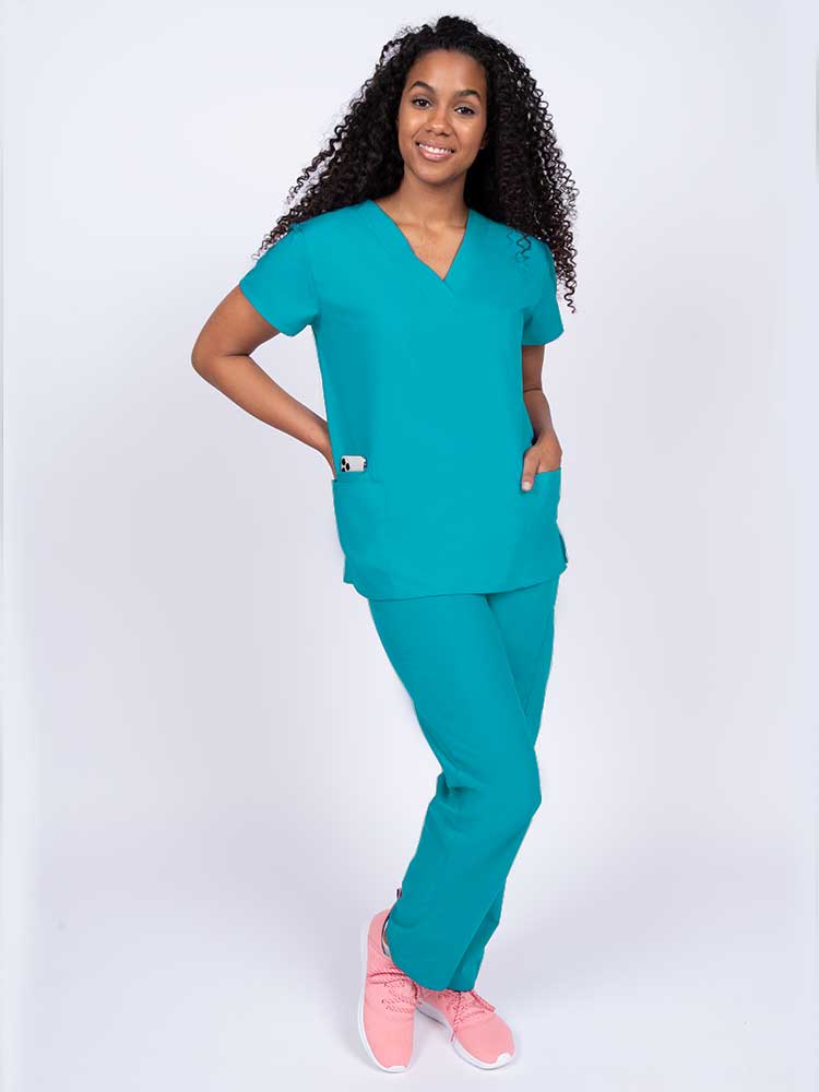 A young female Oncologist wearing a Luv Scrubs by MedWorks V-neck Scrub Top in Turquoise size XL featuring a unique stretch fabric made of 93% polyester and 7% spandex.