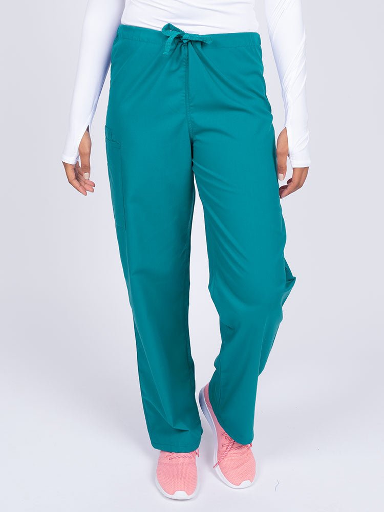 Young nurse wearing a Luv Scrubs Unisex Drawstring Cargo Pant in teal with a total of 3 pockets.
