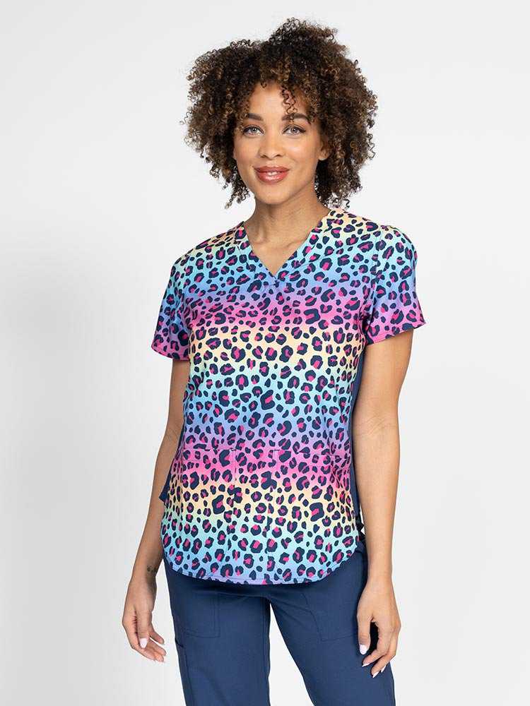 Young healthcare professional wearing a Meraki Sport Women's Print Scrub Top in "Animal Motion" featuring stretch side panels for a comfortable all day fit.
