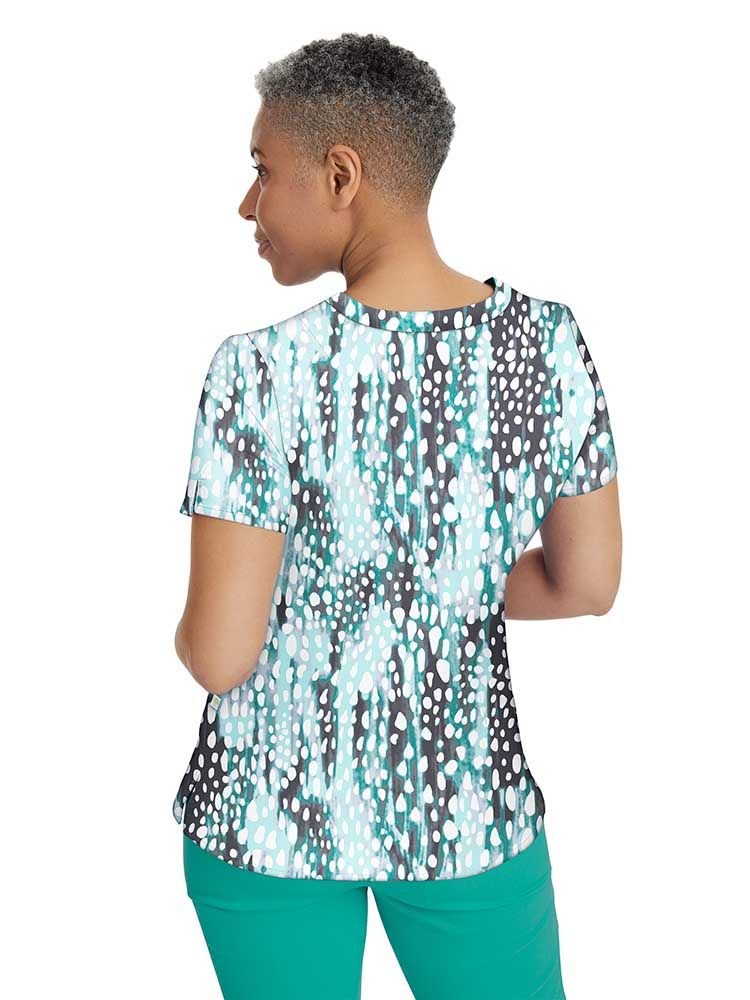 A young female Psychiatric Nurse wearing a Premiere by Healing Hands Women's Amanda Printed Scrub Top in "Crystal Droplets" size Medium featuring a center back length of 26.5".