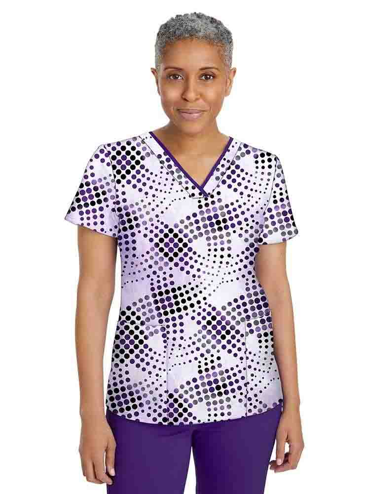 A middle aged Pediatric Nurse wearing a Premiere by Healing Hands Women's Amanda Printed Scrub Top in "Gradient Circles" featuring 2 front welted pockets.