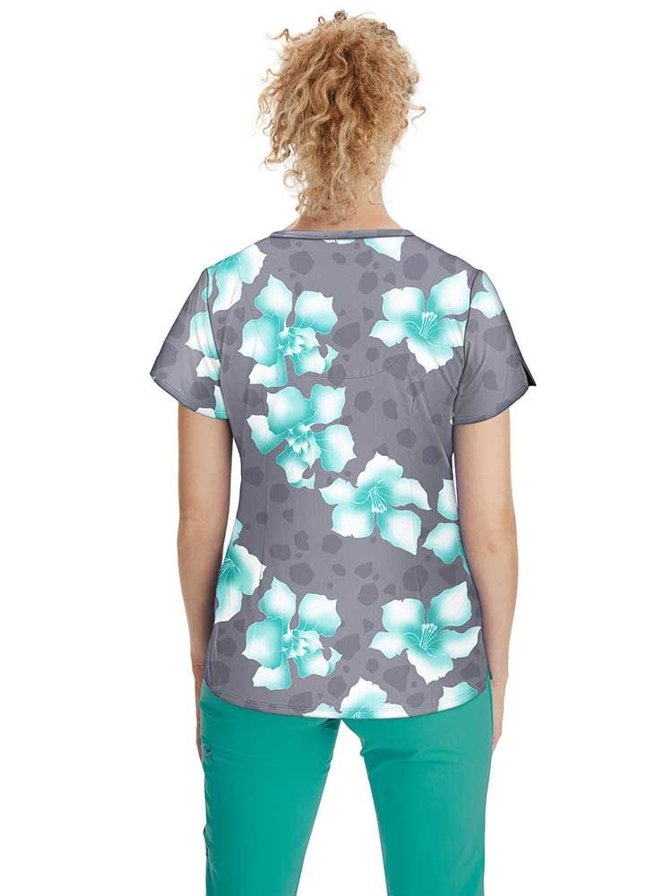 A young female Psychiatric Nurse wearing a Women's Isabel Printed Scrub Top from Premiere by Healing Hands in size Medium featuring a center back length of 26.5".