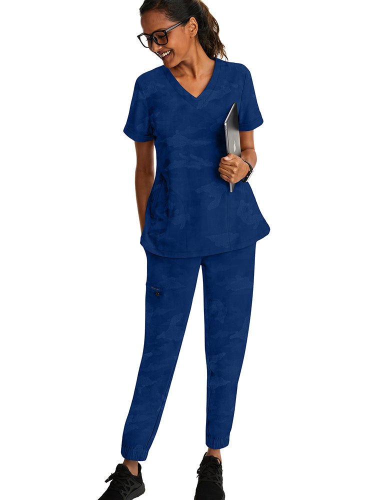 Female healthcare professional wearing a Purple Label Women's Joy Camo Top in Navy featuring a a super soft, blend of stretch fabric that is quick drying.
