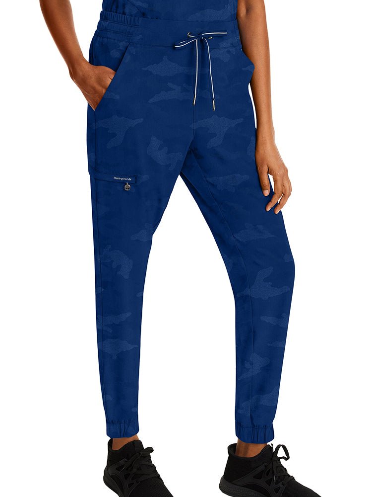 Female healthcare worker wearing a pair of Purple Label Women's Tate Camo Joggers in Navy with back elastic & a flat front.