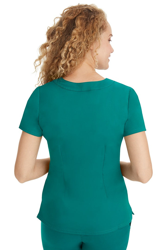 A young LPN wearing a Purple Label Women's Jane V-Neck Scrub Top in Hunter Green featuring a medium center back length of 26.5".
