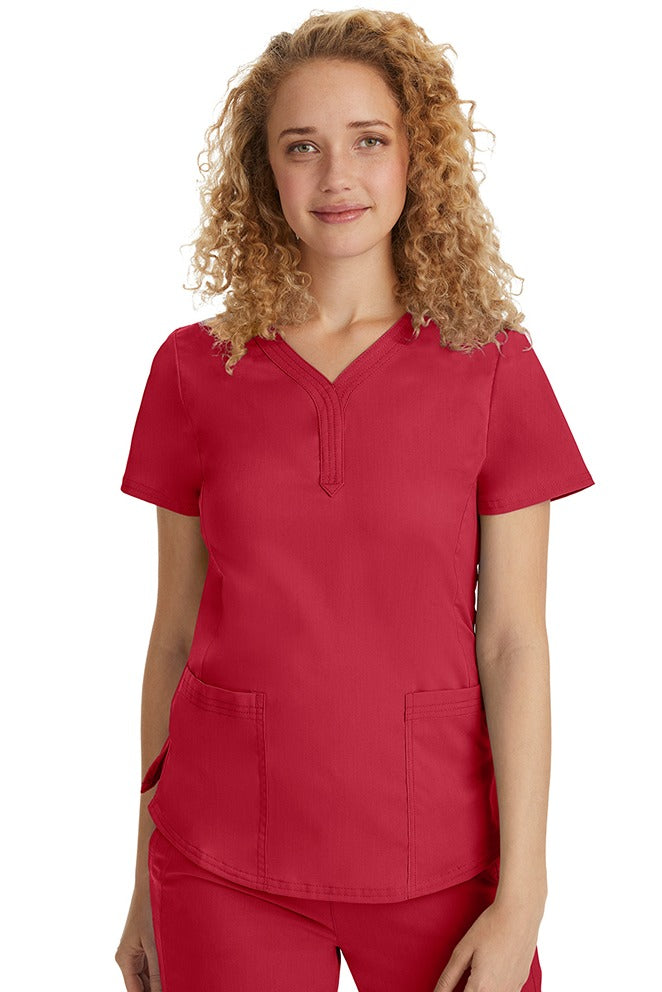 A female Emergency Room Registered Nurse wearing a Purple Label Women's Jane V-Neck Scrub Top in Red featuring front seams for a flattering a fit.