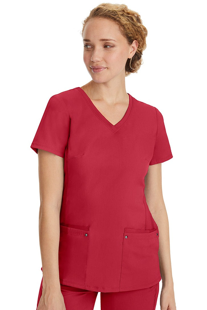 A lady nurse wearing a Purple Label Women's Juliet Yoga Scrub Top in Red featuring a super comfortable stretch fabric made of 77% polyester/20% rayon/3% spandex.