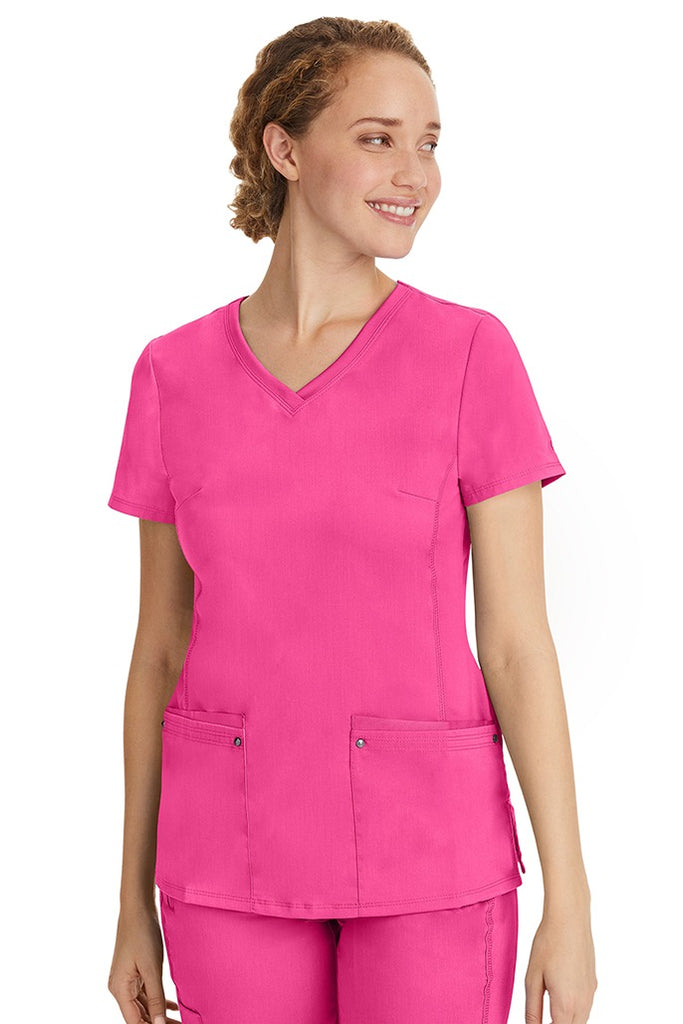A lady nurse wearing a Purple Label Women's Juliet Yoga Scrub Top in Shocking Pink featuring a super comfortable stretch fabric made of 77% polyester/20% rayon/3% spandex.