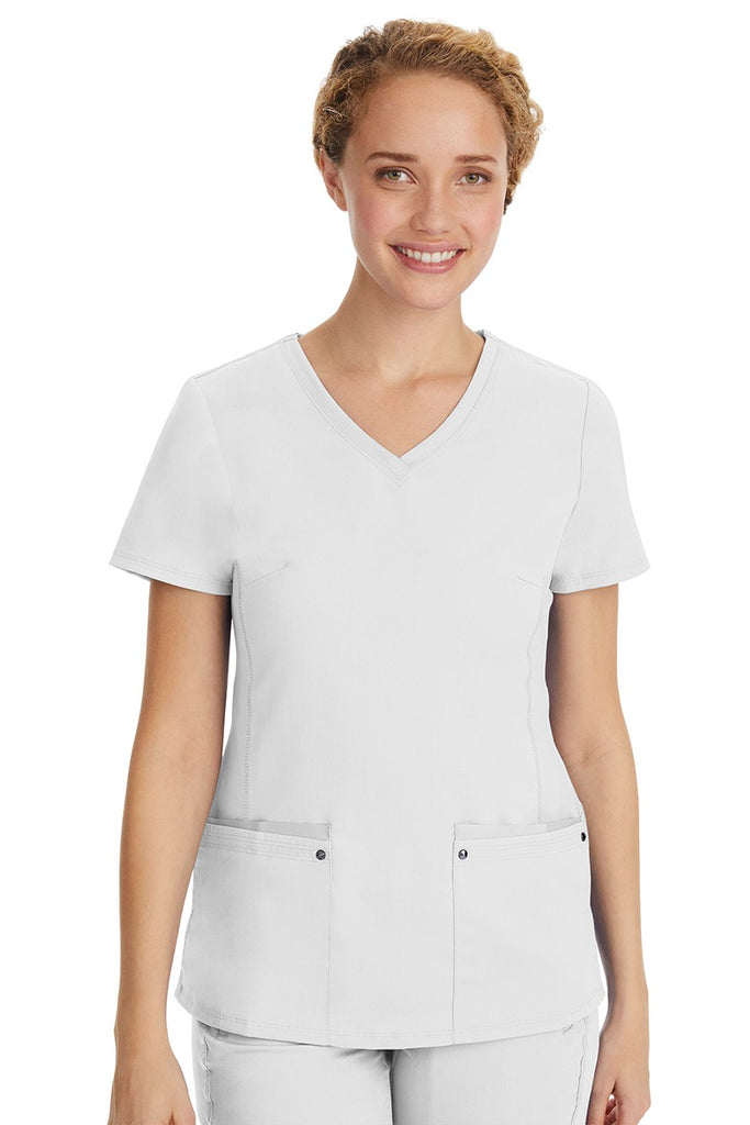 A young LPN wearing a Purple Label Women's Juliet Yoga Scrub Top in White featuring 2 front patch pockets.