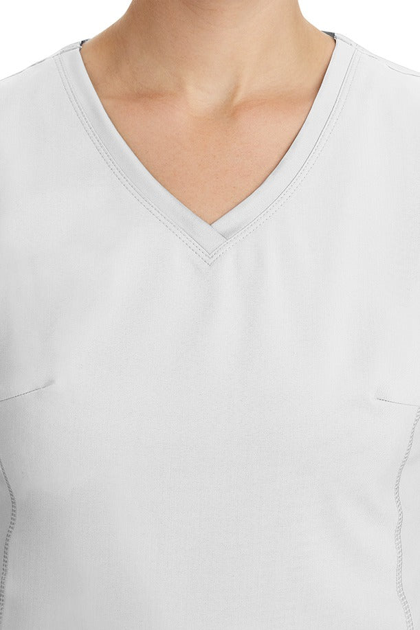 A young healthcare professional wearing a Purple Label Women's Juliet Yoga Scrub Top in White featuring a modern fit.