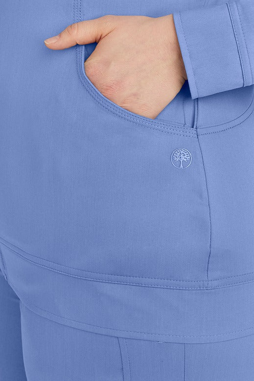 A young Nurse Practitioner wearing Purple Label Women's Dakota Zip Up Scrub Jacket from Healing hands in Ceil featuring triple needle stitching throughout.