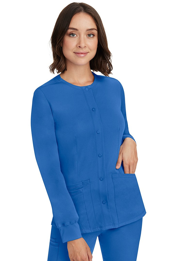 A young lady RN wearing an HH-Works Women's Megan Snap Front Scrub Jacket in Royal featuring front princess seaming to ensure a flattering fit.