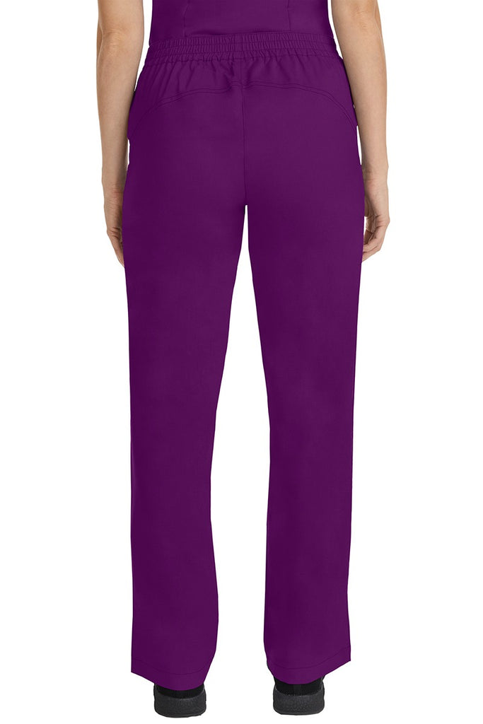 A female CNA wearing a pair of Purple Label Women's Taylor Drawstring Scrub Pants in Eggplant featuring a back yoke to ensure comfortable & flattering all day fit.