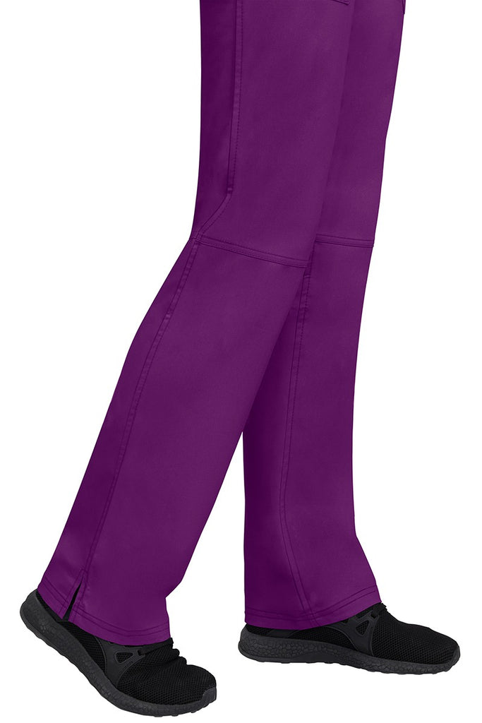 A young woman wearing a pair of Purple Label Women's Tori Yoga Waistband Scrub Pants in Eggplant featuring a fabric made of 77% Polyester/ 20% Rayon/ 3% Spandex.