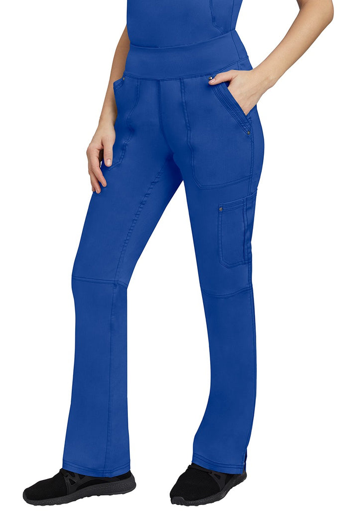 A young Home Care Registered Nurse wearing a pair of Purple Label Women's Tori Yoga Waistband Scrub Pants in Galaxy Blue featuring 1 outer cargo pocket on the wearer's left side pant leg.