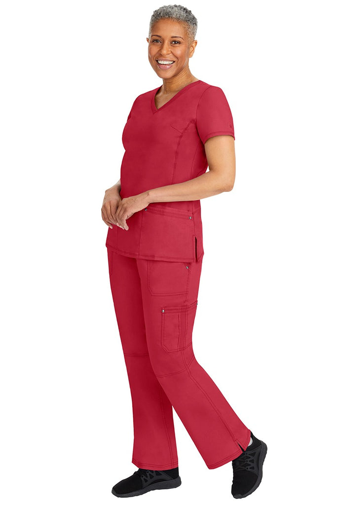 A young female nurse wearing a pair of Purple Label Women's Tori Yoga Waistband Scrub Pants from Healing Hands in Red featuring a modern fit.