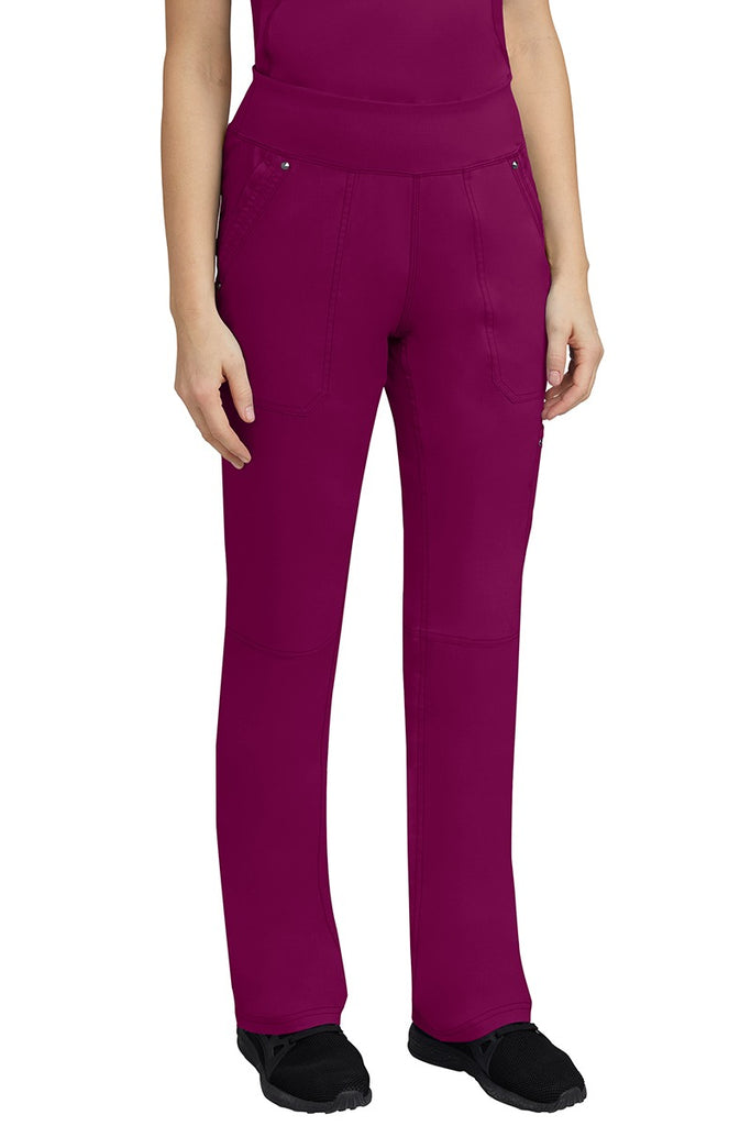 A young woman wearing a Purple Label Women's Tori Yoga Waistband Scrub Pant in Wine featuring a yoga knit waistband.
