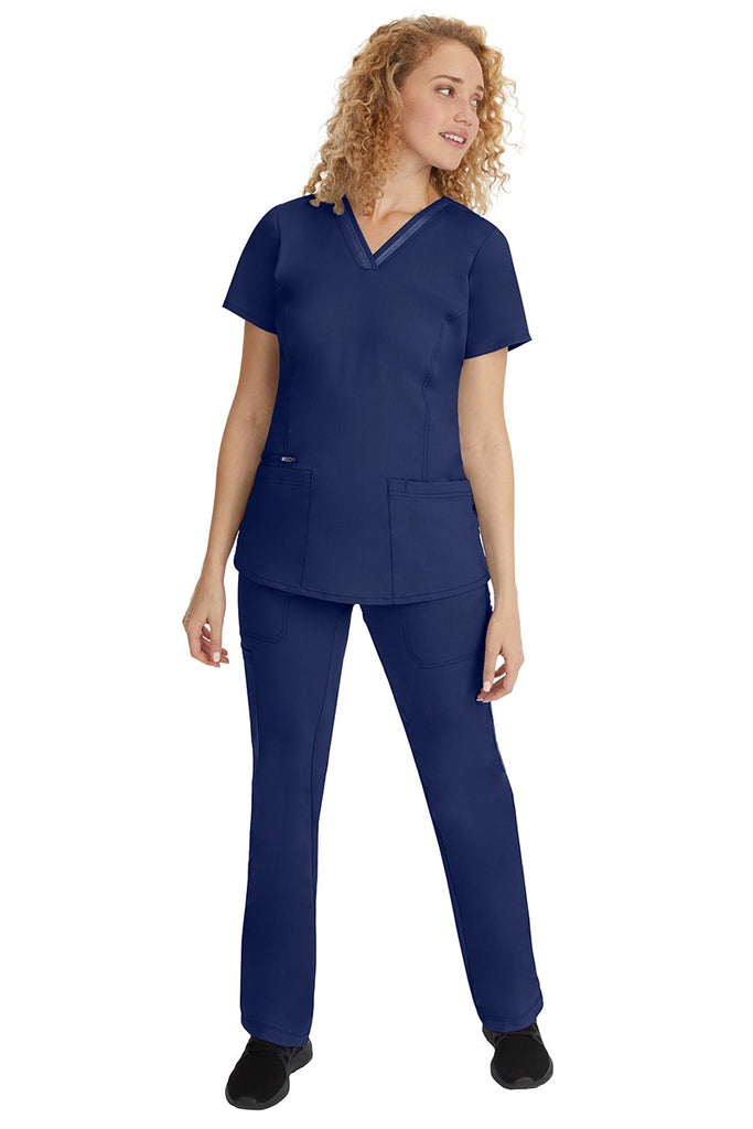 A young woman wearing a pair of Purple Label Women's Tanya Drawstring Cargo Scrub Pant from Healing Hands in Navy size small.