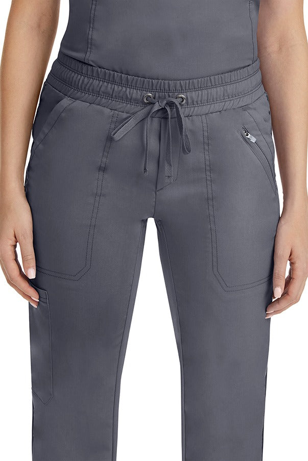 A close up view of a female nurse wearing a Purple Label Women's Tanya Drawstring Cargo Scrub Pant in Pewter featuring a front zipper pocket located on the wearer's left side.