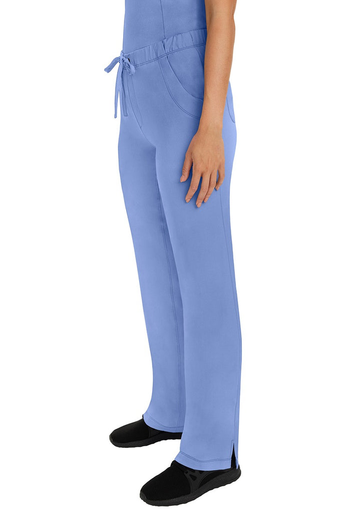 A woman Home Care Registered Nurse wearing a pair of HH-Works Women's Rebecca Multi-Pocket Drawstring Pants in Ceil featuring side slits for additional range of motion.
