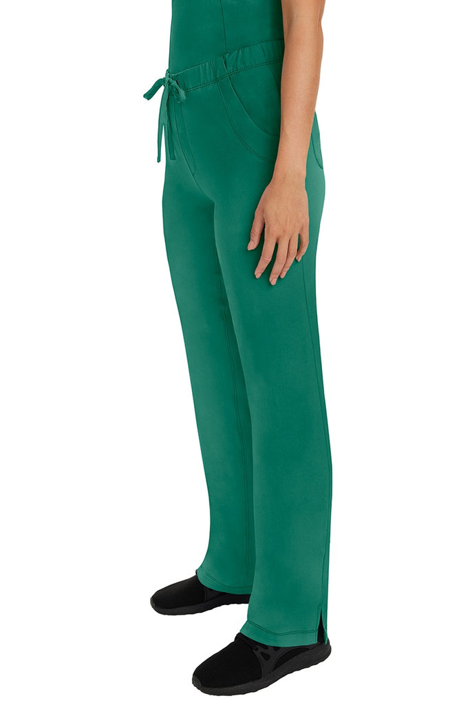 A woman Home Care Registered Nurse wearing a pair of HH-Works Women's Rebecca Multi-Pocket Drawstring Pants in Hunter Green featuring side slits for additional range of motion.