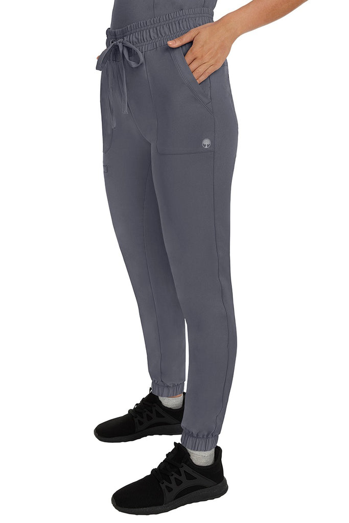 A female healthcare professional wearing a pair of the HH Works Women's Renee Jogger Scrub Pants in Pewter featuring stretchy ankle cuffs at the bottom of each pant leg.