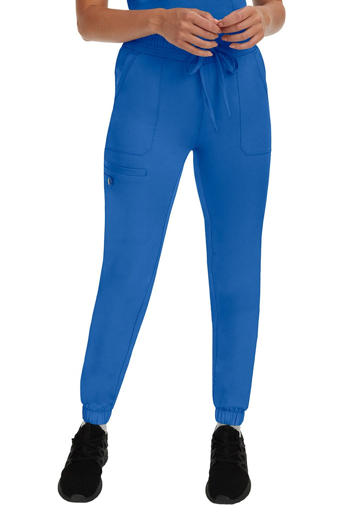 A young woman LVN wearing a pair of the HH Works Women's Renee Jogger Scrub Pants in Royal featuring a super comfortable, easy care fabric.
