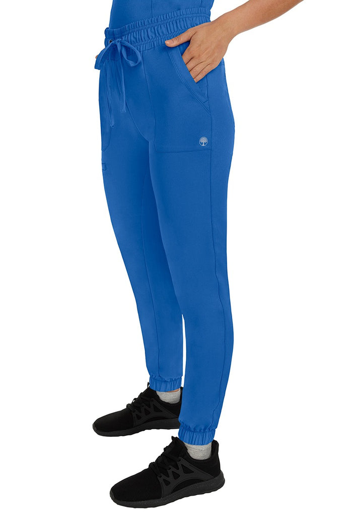 A female healthcare professional wearing a pair of the HH Works Women's Renee Jogger Scrub Pants in Royal featuring stretchy ankle cuffs at the bottom of each pant leg.