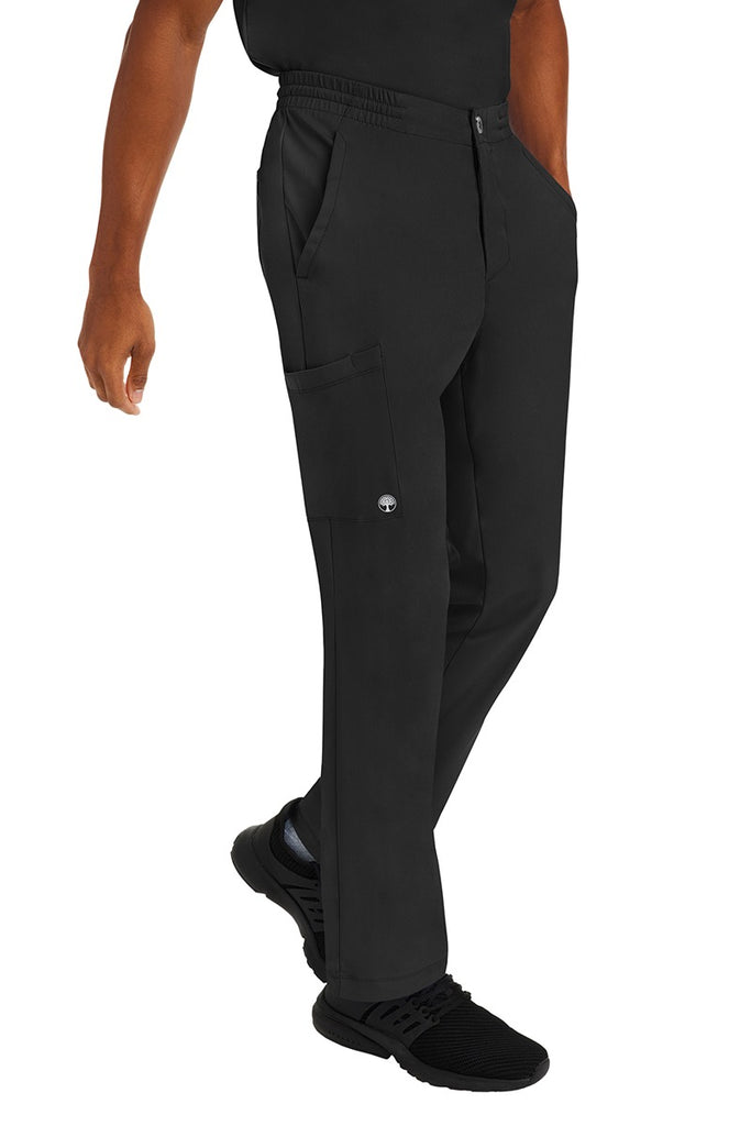A young male CNA wearing a pair of HH-Works Men's Ryan Multi-Pocket Cargo Scrub Pants in Black featuring two front patch pockets.