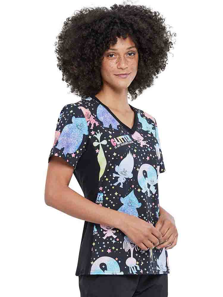 A young female Nurse wearing a Tooniforms Women's V-neck Printed Scrub Top in "Glitter Trolls" featuring side panels.