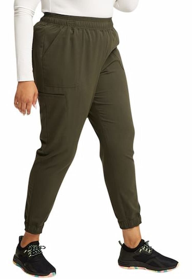 A young female Physician's Assistant wearing a Vince Camuto Women's Mid Rise Scrub Jogger in Heathered Olive size XS featuring elasticized cuffs.