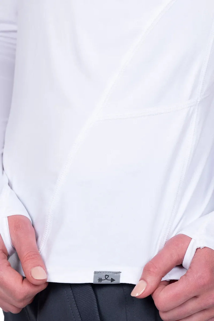 An up close image of the sleeves and front of the Ava Therese Women's Lily Tee in White size XS featuring long sleeves and thumb holes.