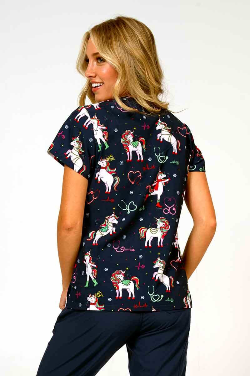 A young lady nurse wearing a Meraki Sport Women's Print Scrub Top in "Jolly Nursicorn" size XS featuring shoulder yokes & side slits for additional range of motion.