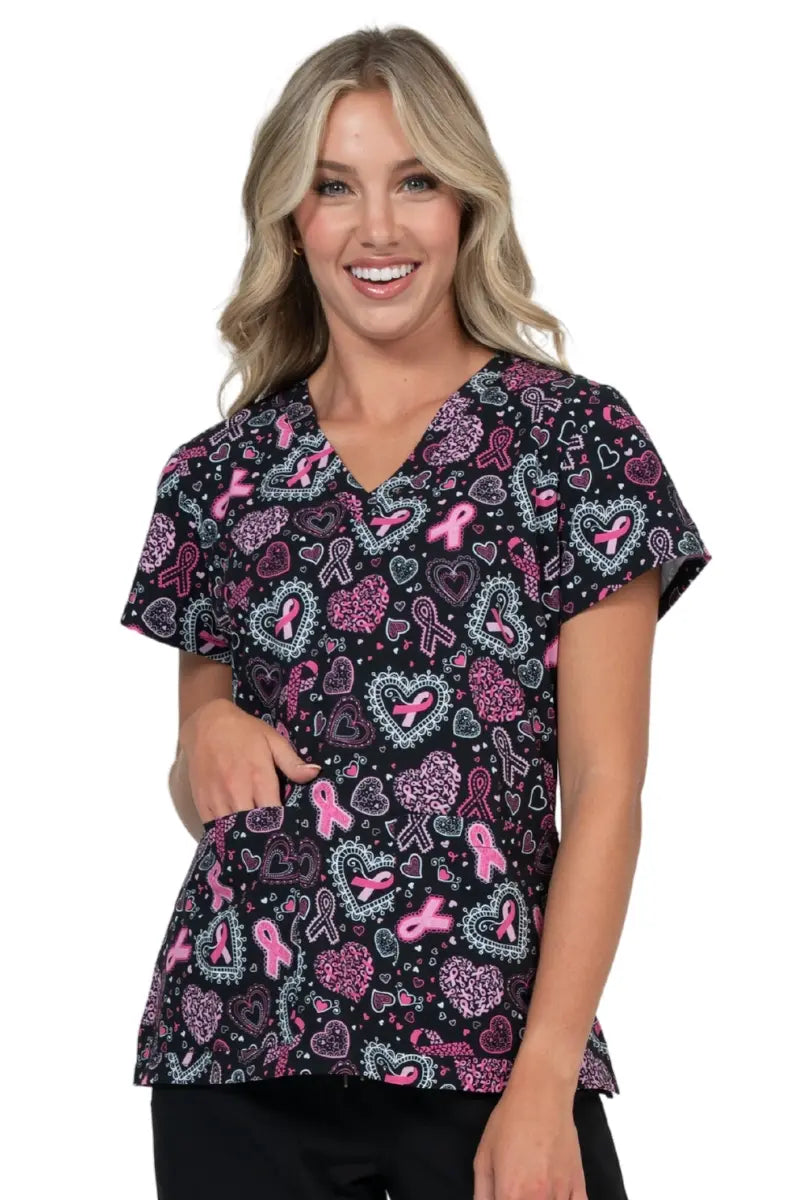 Nurse wearing Meraki Sport Breast Cancer Awareness pink ribbon scrub top.