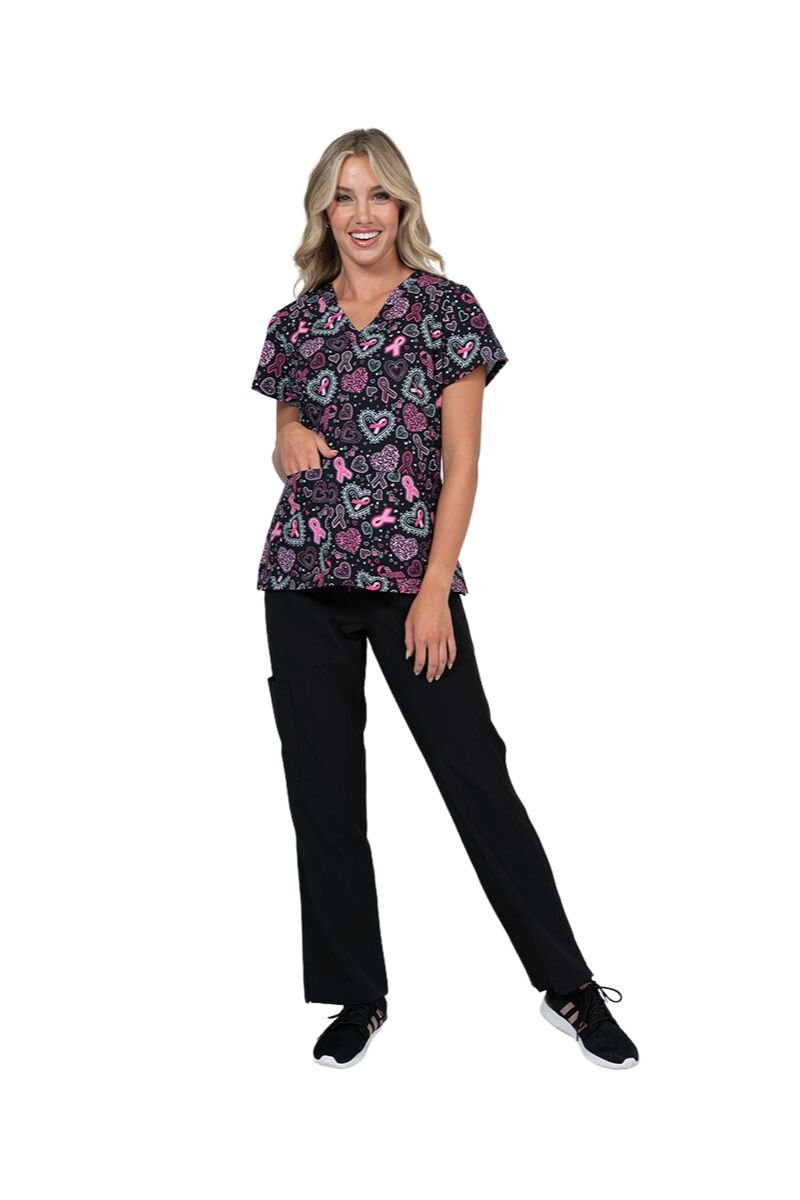 An image of a young female Pediatric Nurse Wearing a Meraki Sport Women's Breast Cancer Awareness Printed Scrub Top in "Pink Strength" size XS featuring a contemporary fit with short sleeves.