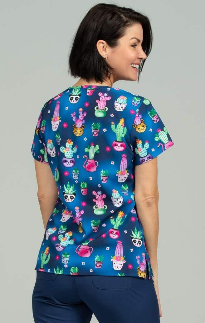 A young female Phlebotomist wearing a Meraki Sport Women's Print Scrub Top in "Stuck on You" size 2XL featuring shoulder yokes & side slits for additional range of motion.