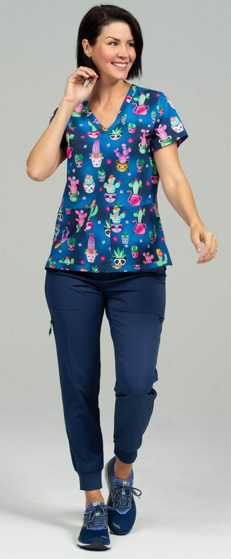 A female LPN wearing a Women's Print Scrub Top from Meraki Sport in "Stuck on You" size Small featuring 2 front patch pockets & shoulder yokes for a flattering shape.