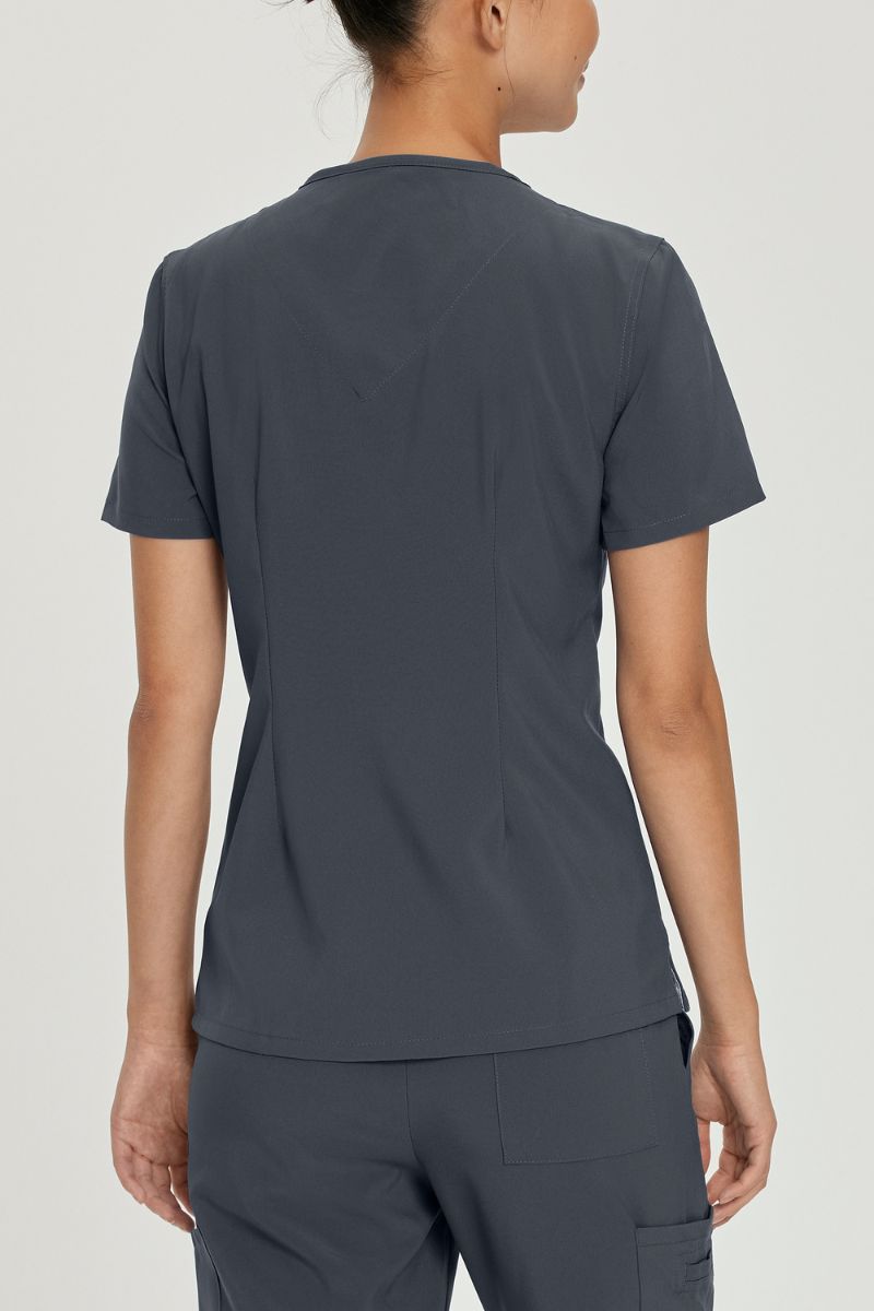 A young female Medical Assistant waring an Urbane Performance Women's Motivate V-neck Scrub Top in Graphite size Medium featuring a center back length of 26.5"