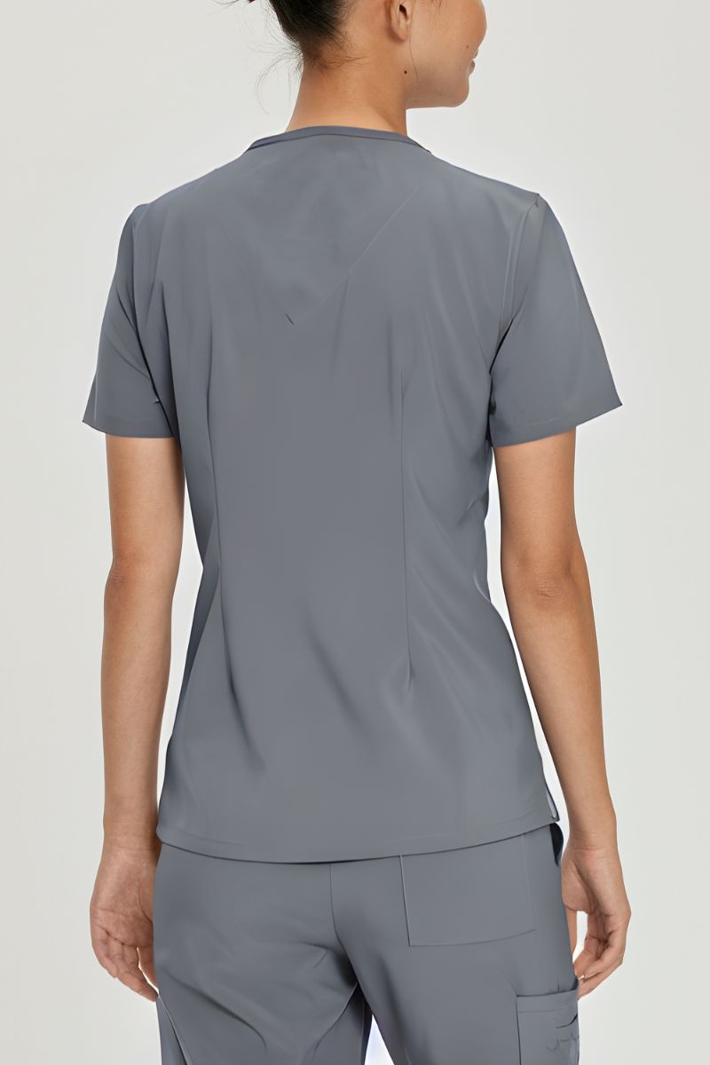 A young female LVN wearing an Urbane Performance Women's Motivate V-neck Scrub Top in Steel size Medium featuring a center back length of 26.5"