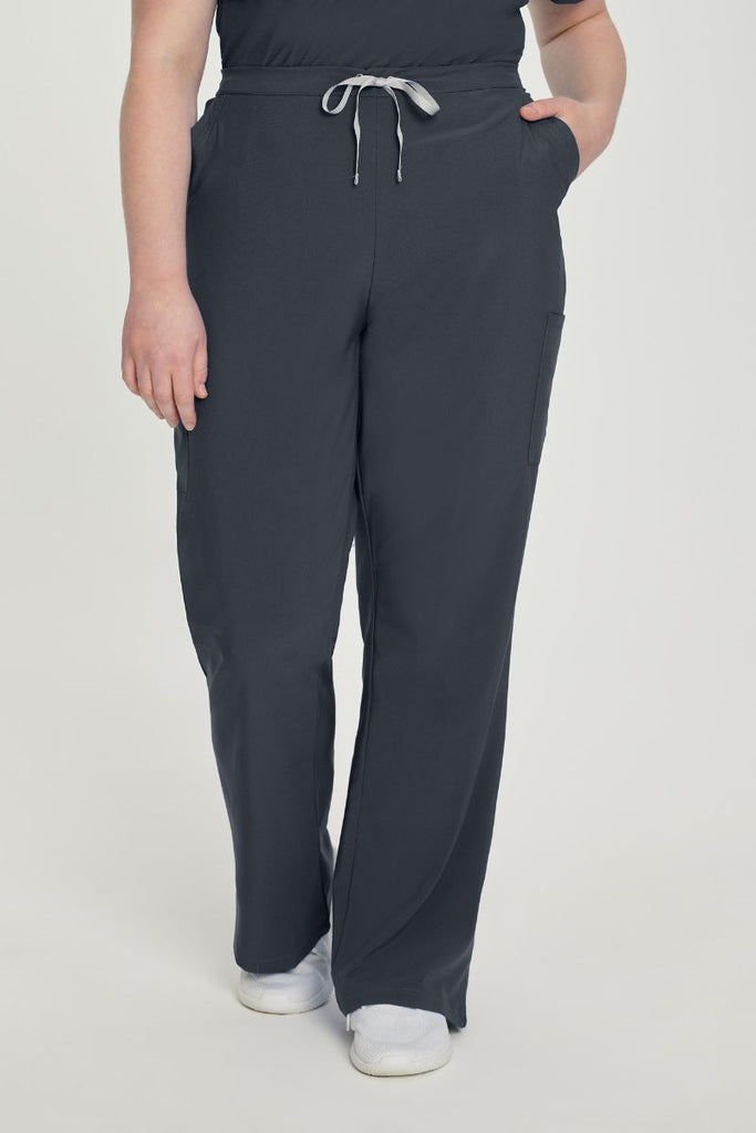 A female Hospital Administrator showcasing the front of the Urbane Performance Endurance Cargo Pants in Graphite size 5XL featuring a yoga-inspired design that lets you bend, reach, and move freely throughout your shift.