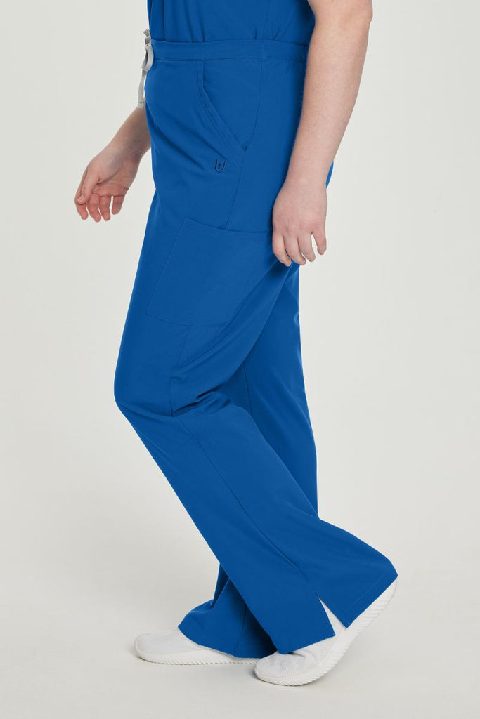 A young female Doctor wearing a pair of the Urbane Performance Endurance Cargo Scrub Pants in New Royal size 2XL featuring side vents to keep the wearer cool, while on the go.