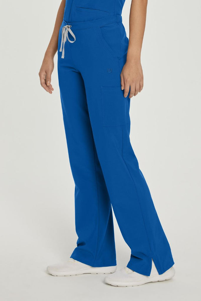 A young female Nurse wearing a pair of Urbane Performance Endurance Cargo Scrub Pants in New Royal featuring 6 pockets in total, for all of your on the job storage needs.