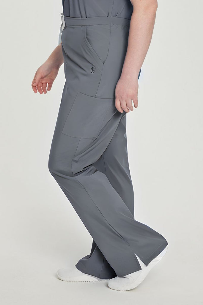 A young female Pharmacy Tech wearing a pair of the Urbane Performance Endurance Cargo Scrub Pants in Steel size XL featuring a breathable fabric wicks away moisture, keeping you cool and comfortable even during demanding tasks.