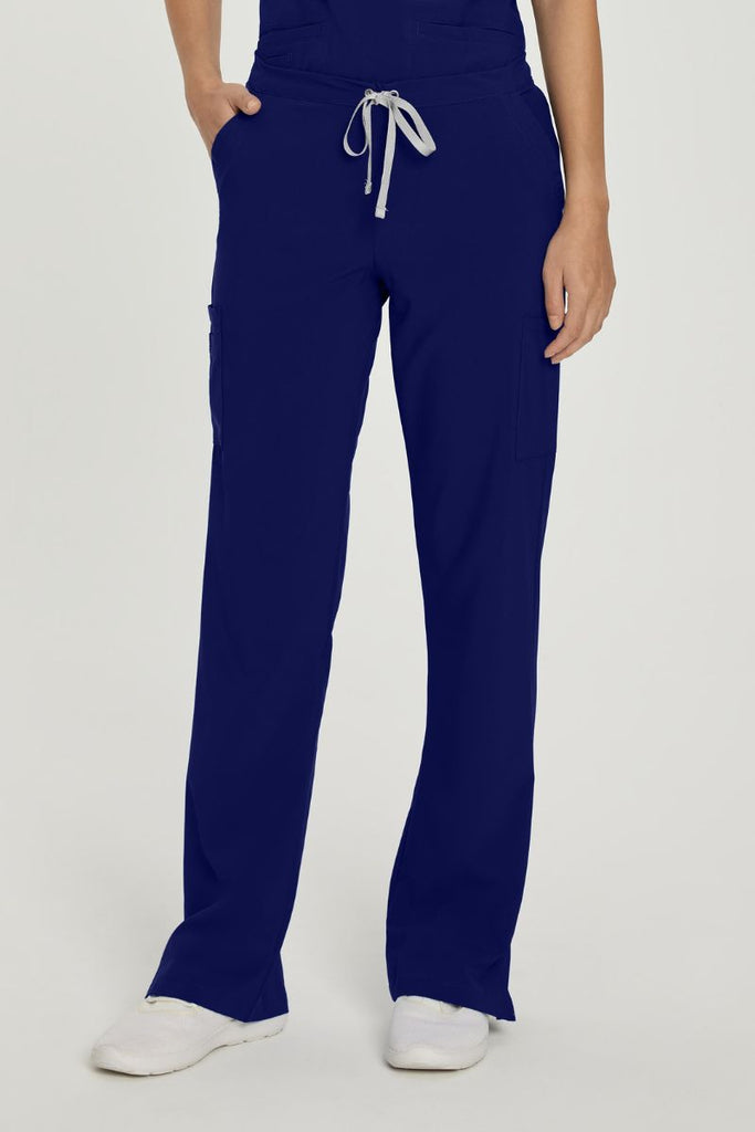 A young female CNA wearing a pair of Urbane Performance Endurance Cargo Pants in Navy size Small featuring a modern, tailored silhouette.