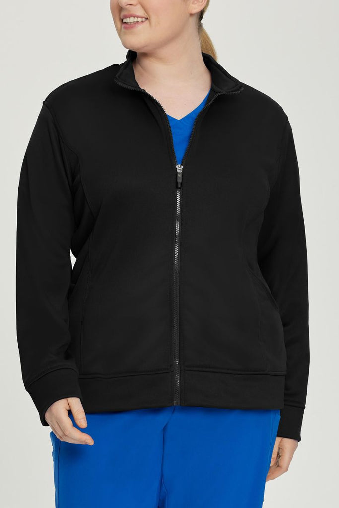 A young female Physical Therapist wearing an Urbane Performance Women's Zip-Up Scrub Jacket in Black size 3XL featuring a convenient zip-up closure.