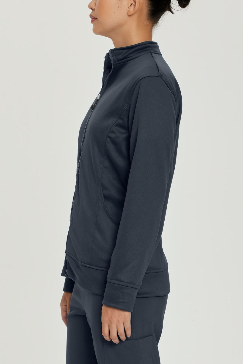 A young female Lab Tech showcasing the side of the Urbane Performance Women's Zip-Up Scrub Jacket in Graphite size Large featuring princess seaming throughout to provide a flattering shape.