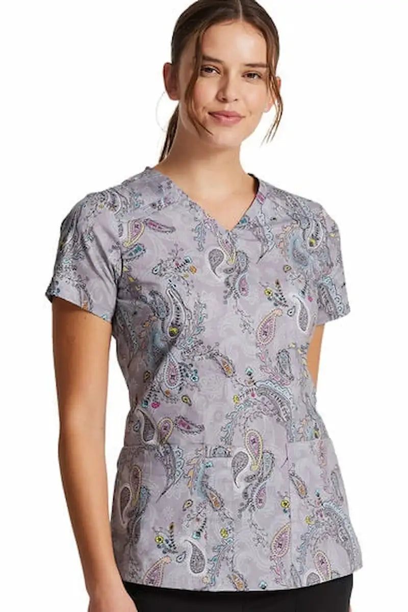 A young female Nurse wearing a Dickies Women's V-Neck Print Scrub Top in Denim Paisley featuring a flattering v-neckline.